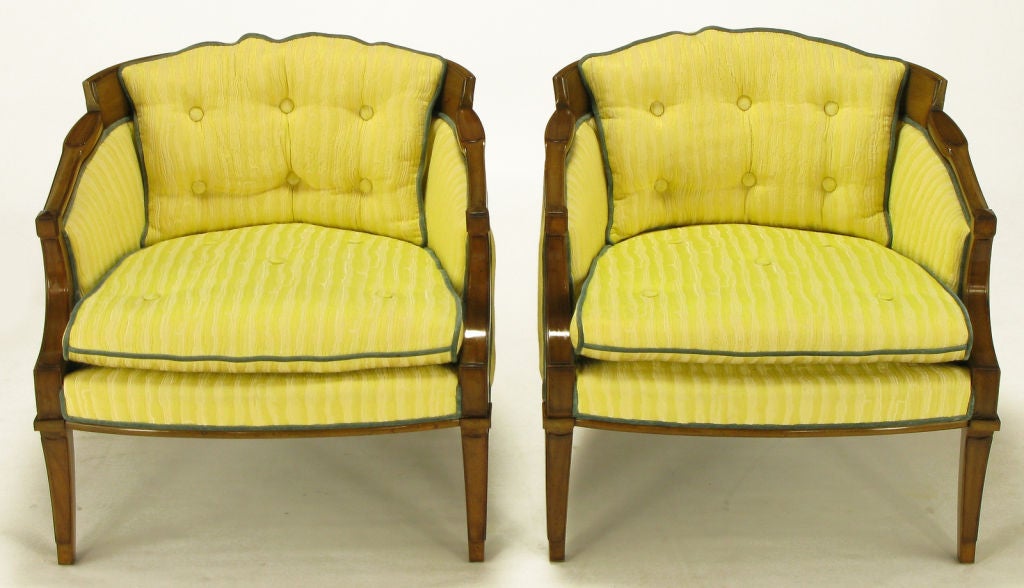 Pair of Oxford Ltd lounge chairs with carved walnut regency frame. Saber front and back legs with nicely detailed arms and back. Fixed button tufted back cushion, loose seat cushion in a saffron striped linen and silk blend upholstery,  with