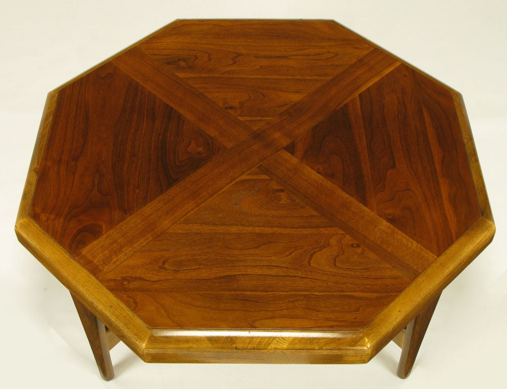 Octagonal coffee table with radius edging and figured walnut parquetry top with X-pattern that is carried through to the bottom paddle end X-stretcher. Superior build quality with burned in style and serial numbers to the underside of the top.