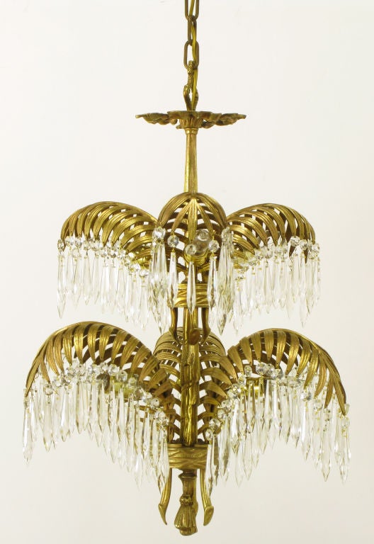 Excellent restored bronze d'ore palm frond chandelier stamped NY Lighting Company and in the manner of Maison Bagues. Six palm stalks in two tiers with cascading crystals meet at the center rope-like stem. Cast bronze with aged gilt finish and six