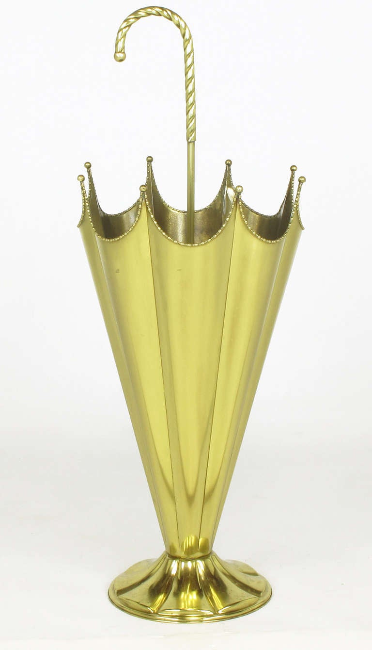 Fanciful umbrella stand in the form of a brass, partially open umbrella. Excellent attention to detail with the umbrella ribs finishing in tiny brass balls and the partially collapsed shade finished in brass beading. Mounted on a fluted brass