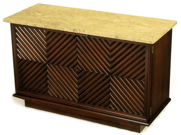 Heritage Henredon walnut petite cabinet with reeded chevron doors cabinet, and carved wood pulls. Travertine top with single shelf and recessed plinth base. Perfect for a flat screen T.V. and media storage.