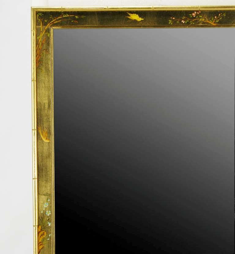 LaBarge gilt and hand-painted wall mirror. Gilt finish with amber lacquer and hand painted with Asian flora and fauna. Carved wood frame bordered with a stylized bamboo. Signed. Measures: 50”.