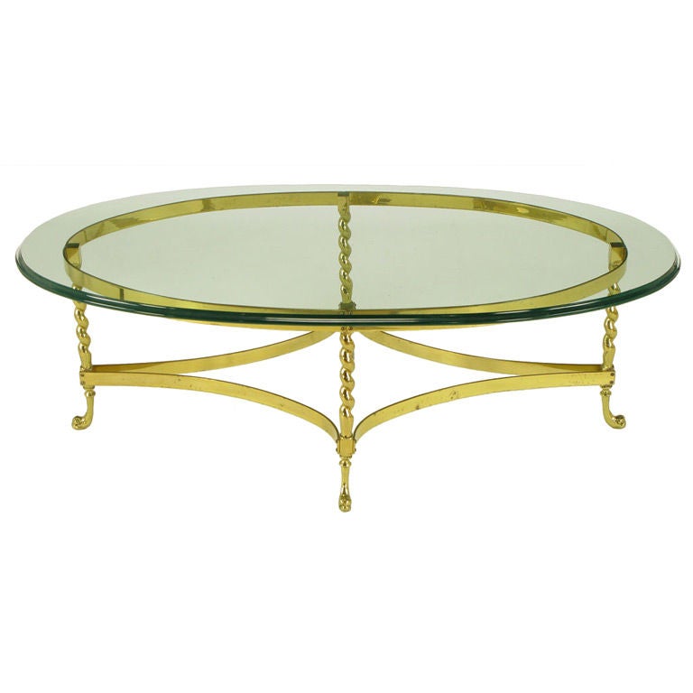 Solid brass oval coffee table with barley twist legs and dolphin head feet. Reverse quatrefoil brass stretchers with a beveled glass 1/2