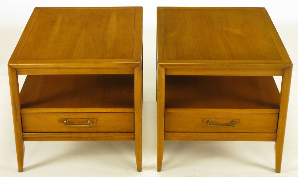 Pair of bleached mahogany two tier end tables with lower drawer by Drexel. Recessed apron and drawer casement, tapered legs and incised bordered top. Burled olive wood escutcheon with brass drop U pulls.  Finished on all four sides.  Turned