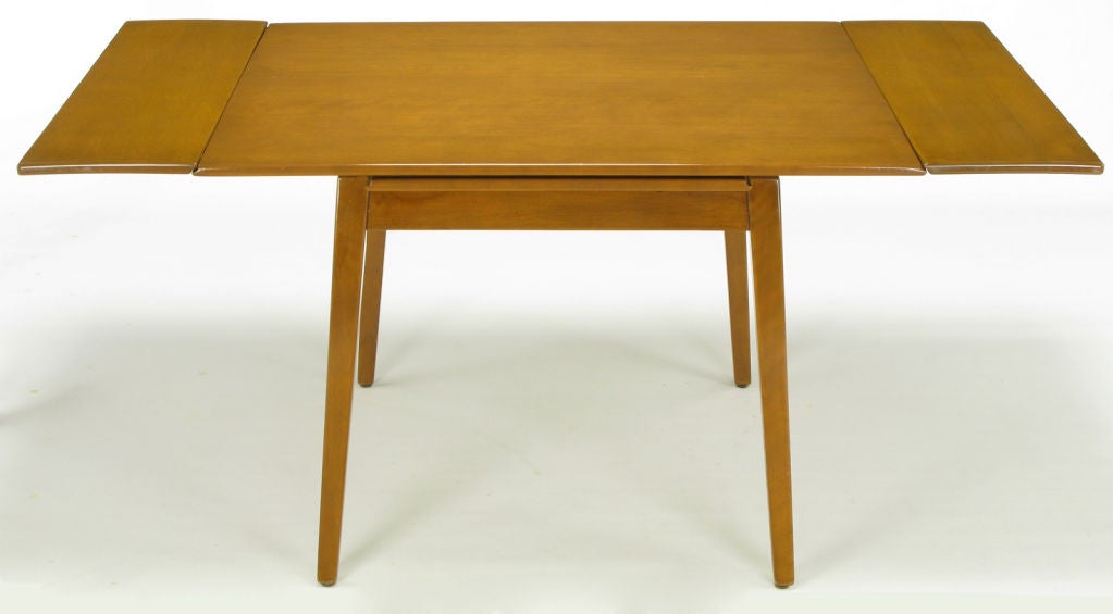 A circa 1950s petite dining table in birch from the Contemporary Line of the Imperial Furniture Company. Perfect for a smaller space with the ability to expand to 62