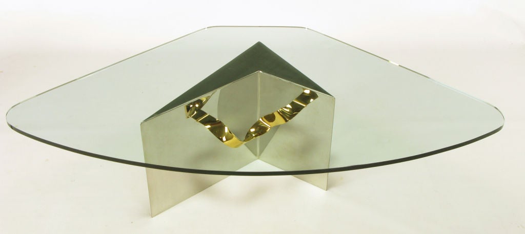 A bit of a Postmodern design, this table features a highly polished stainless steel chevron-form base, with brass ribbon appearing to run through it. Fitted glass top.
Square glass for illustration purposes is 40