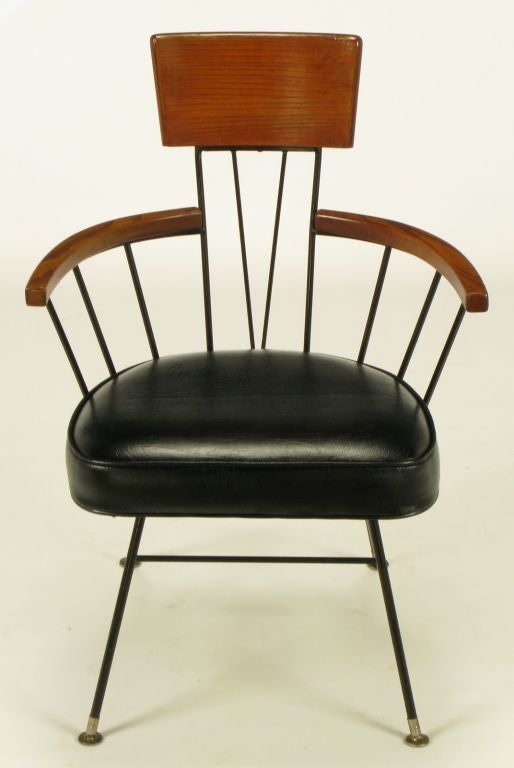 Set four Paul McCobb dining chairs comprised of black lacquered wrought iron frames with steel sabos and glides. Ash wood arms and backs. Black leather-like upholstered seat cushions. Additional set of six chairs available.<br />
<br />
<br