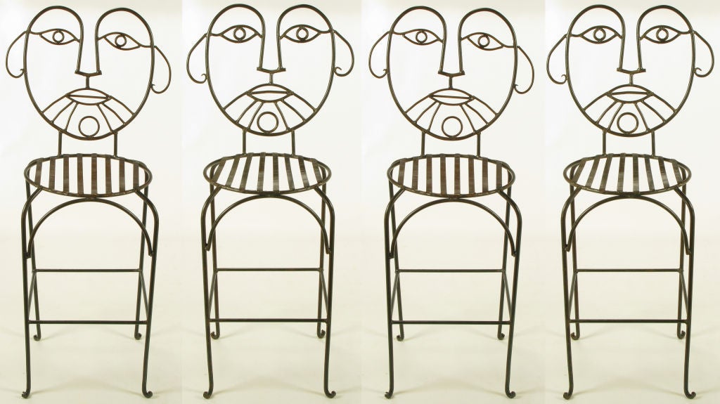 Set of four wrought and glazed iron barstools with round metal slat seats and figural backs in the shape of a mans stylized face. Similar to wrought iron furniture by metal artist John Risley.