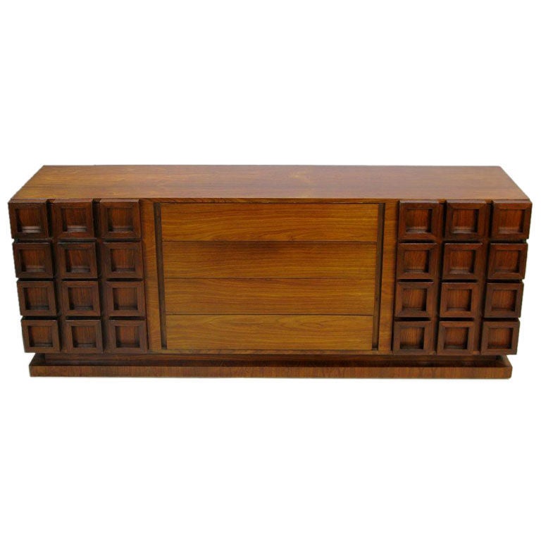 An exceptional design, this dresser is heavily constructed, with a very rectilinear form. It has a plinth base, separated from the upper case by a negative reveal.<br />
<br />
The central four drawers are faced in solid walnut. Behind the left