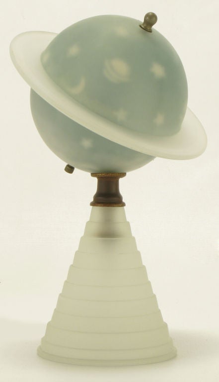 Art deco etched opaque and blue reverse painted planetary desk lamp of the planet Saturn. Sold in commemoration of the 1939 World's Fair in New York. Conical art deco etched glass base brass spacer with reverse etched blue cased glass Saturn with