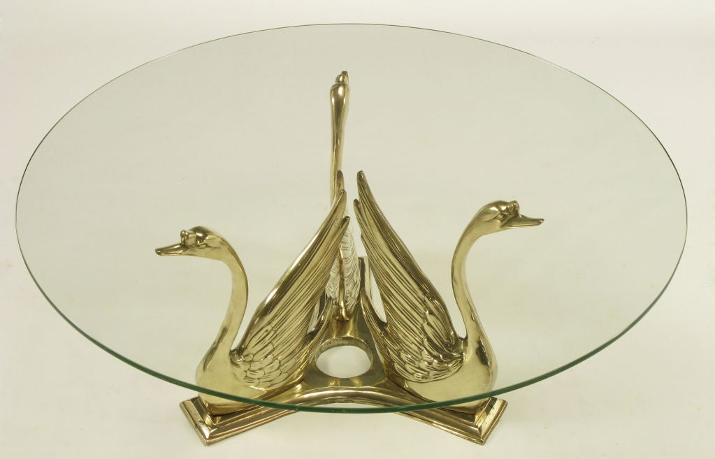 Solid brass trio of swans mounted on a solid brass reverse trefoil base. Polished to a brilliant brass tone with minimal patina. Glass top is 1/2