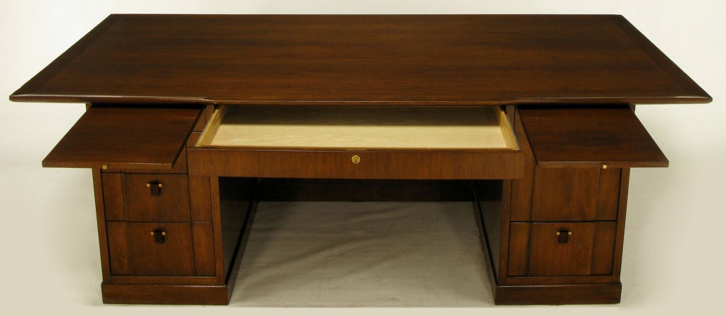 Rare Edward Wormley for Dunbar sculpted walnut and rosewood executive desk. Upturned carved lip to the solid walnut top that levels out at the knee hole center. Eight drawers with locking center drawer and hanging file drawer. Pull out right and