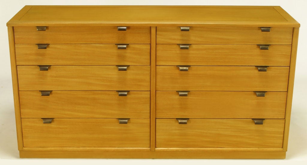From Drexel's Precedent Collection, Edward Wormley ten drawer caramel glazed silver elm dresser with aged brass over zinc pulls. Recessed plinth base on all four sides. Second identical 10 drawer dresser available to make a pair, if desired.