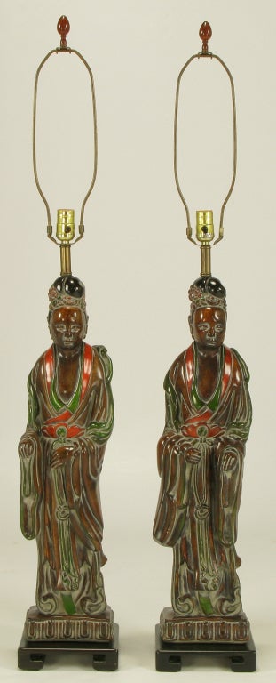 Pair of carved and polychrome wood Asian female form statue table lamps. Antique glazed wood tones with red and green accented gowns and each 29