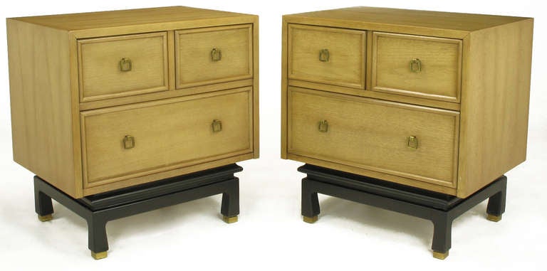 Pair of bleached and glazed mahogany chinoiserie night stands or end tables with recessed picture frame drawer fronts. Drop ring brass pulls are squared and sans escutcheons. Black lacquered and recessed four leg platform base with brass sabots.