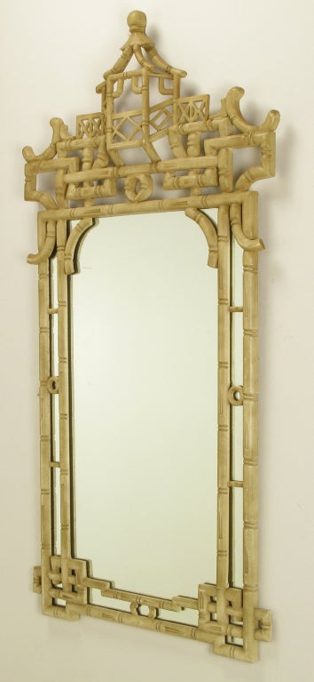 Cast resin and crackle glaze antique ivory lacquer Chinese Chippendale style mirror. Bamboo form pierced framework and mirrored glass with projected pagoda surmount.