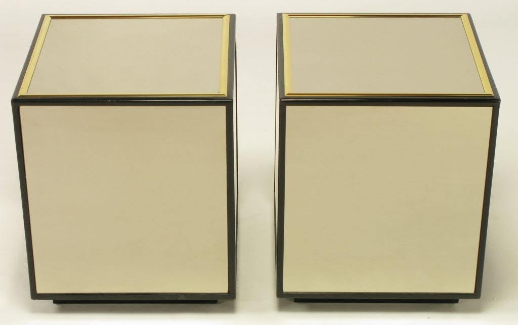 A terrific and versatile pair of tables with gold-bronze mirrored sides and tops. Mirror panels are inset into black lacquer framework, and trimmed with brass moldings. Could be used for coffee tables, end tables, or side tables.