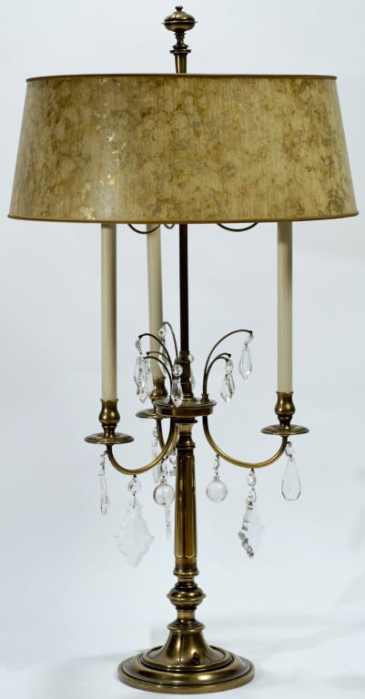 In excellent original condition, these sizable three-arm lamps are made of brass, with hanging crystals. With original cream and gold tortoise shell shades, and stately finials.