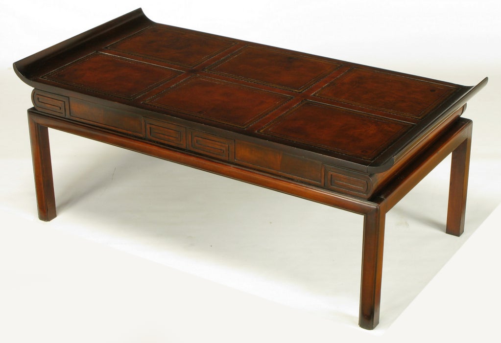Asian inspired coffee table with curved edge tops and tooled leather inlay. The fronts and finished backs have Greek key carved recesses. Radius front legs and back legs. See our other listings for the matching side tables.