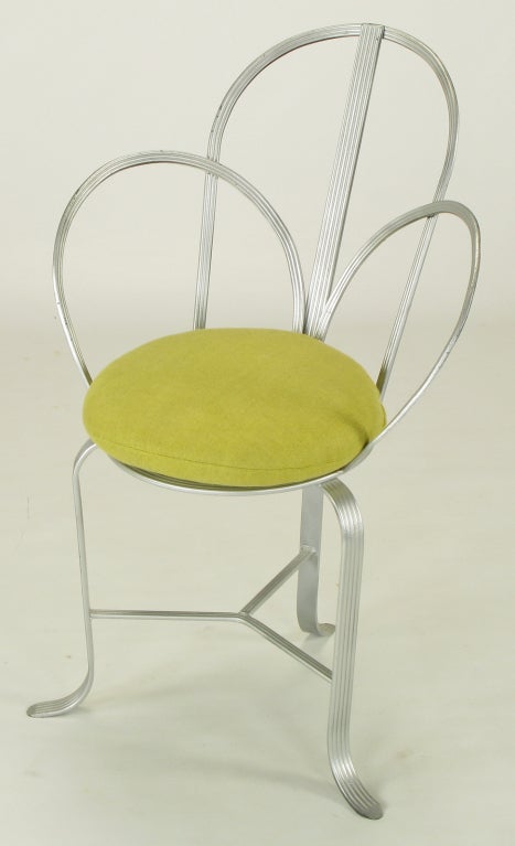 Wrought iron framed architecturally inspired chair with arched three part back and sides constructed of incised flat wrought iron bars and silver enamel. Circular seat with woven iron center, three legs with turned feet and three part stretcher.