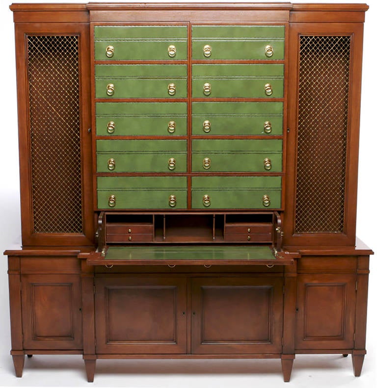 Stunning design for Johnson furniture. Green embossed leather fronts, with brass drop ring pulls, that appear to be all drawers. Starting from the bottom, the lowest pair of drawer fronts conceals a pull-out writing desk or secretary. The next pair