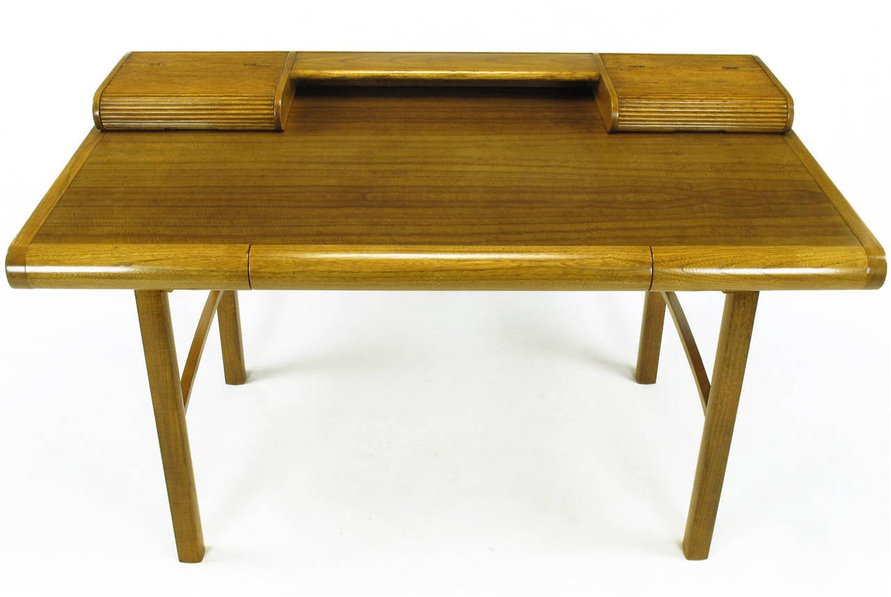 Rare and completely restored, Bert England for Baker postmodern writing table. Figured East Indian laurel wood and ash in a post modern form with arched stretchers and reeded oval top compartments. Single center drawer.