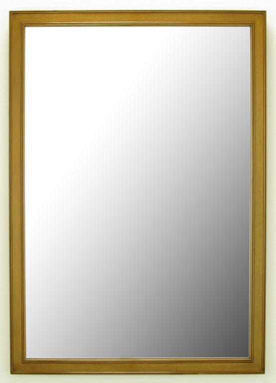 Miroir vertical simplement détaillé de près de quatre pieds de haut avec deux bordures dorées à double perles sur un cadre en acajou blanchi et glacé.