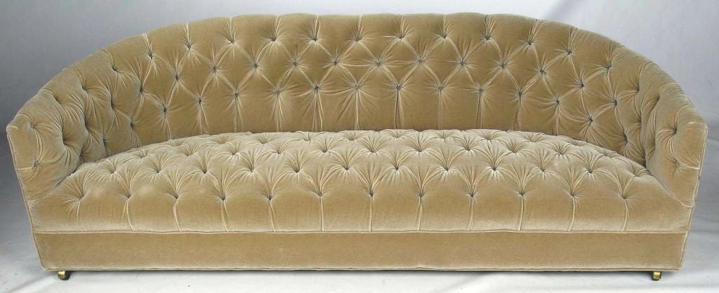 Elegant sloped shoulder sofa from the early years of Baker. Reupholstered in the 1990s in champagne velvet and still in wonderful condition. There are a few tiny unobtrusive places on the seat where the nap has thinned. Comes with the original brass
