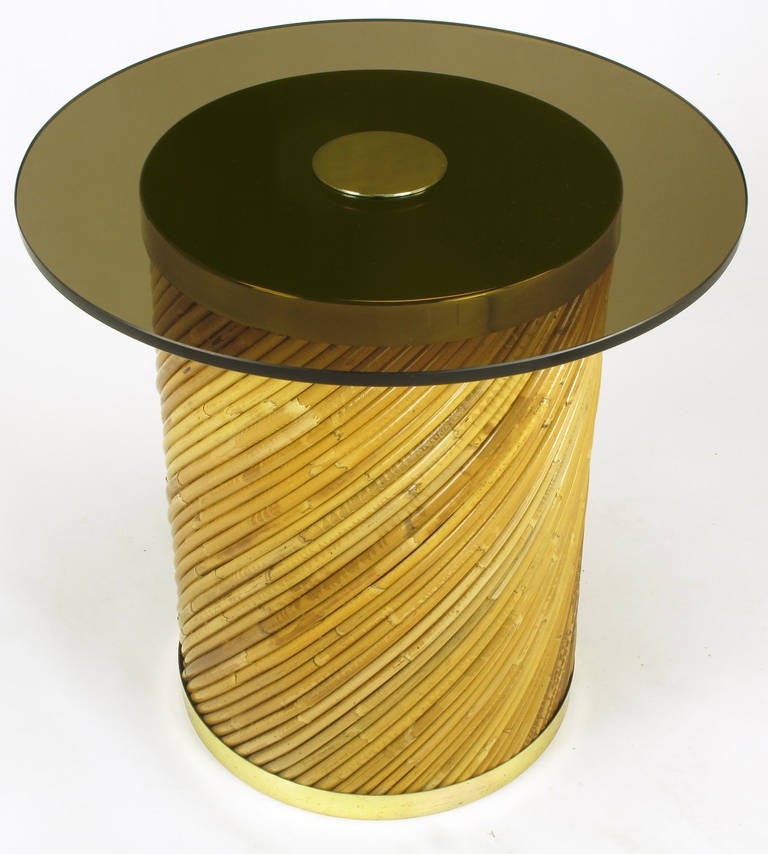 Reeded bamboo on a diagonal plane covering a wooded cylinder. Brass capped top and bottom with a dark tinted glass surface. Centre drilled with a brass disc holding the glass in place.