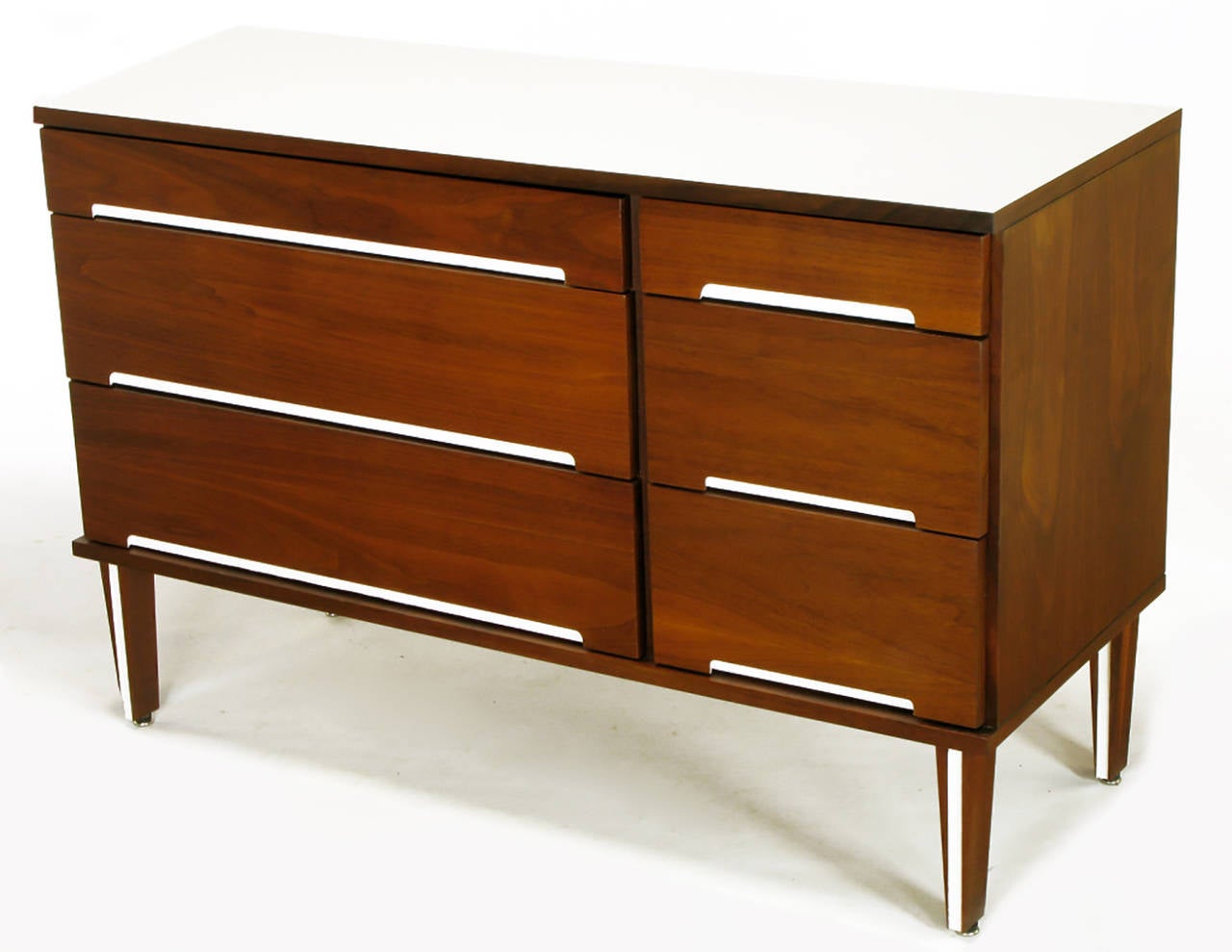 Six-drawer walnut dresser with recessed white lacquer drawer pull openings. Tapered solid walnut legs with white lacquered incision. White Micarta top. Could also function as a small credenza. Similar to designs offered by Herman Miller. Please