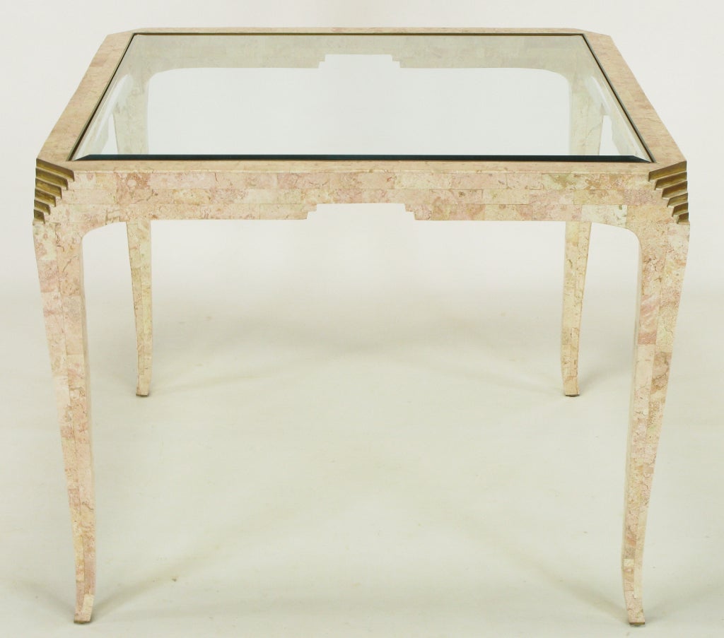 Elegant and well executed tessellated fossil stone art deco revival game table designed by Merle Edelman for Casa Bique. Wonderful pink rouge coloring in the stone.  Thin and tapered legs with stepped brass accent to the canted corners. Brass banded