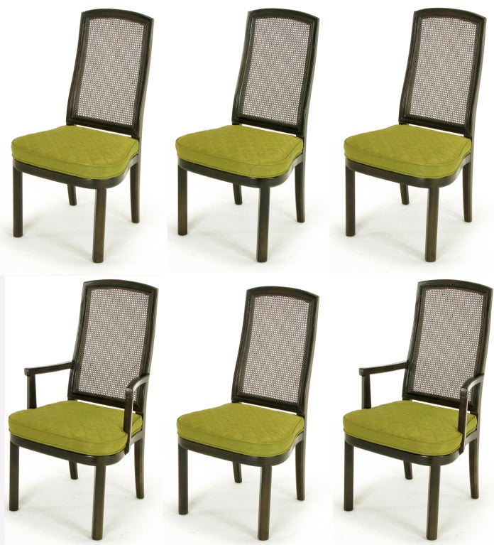 Set of six Asian inspired ebonized mahogany and cane dining chairs from Henredon Furniture. A pair of arm chairs and four side chairs with canted front legs, curved apron, caned back and original olive green trapunto-quilted silk damask