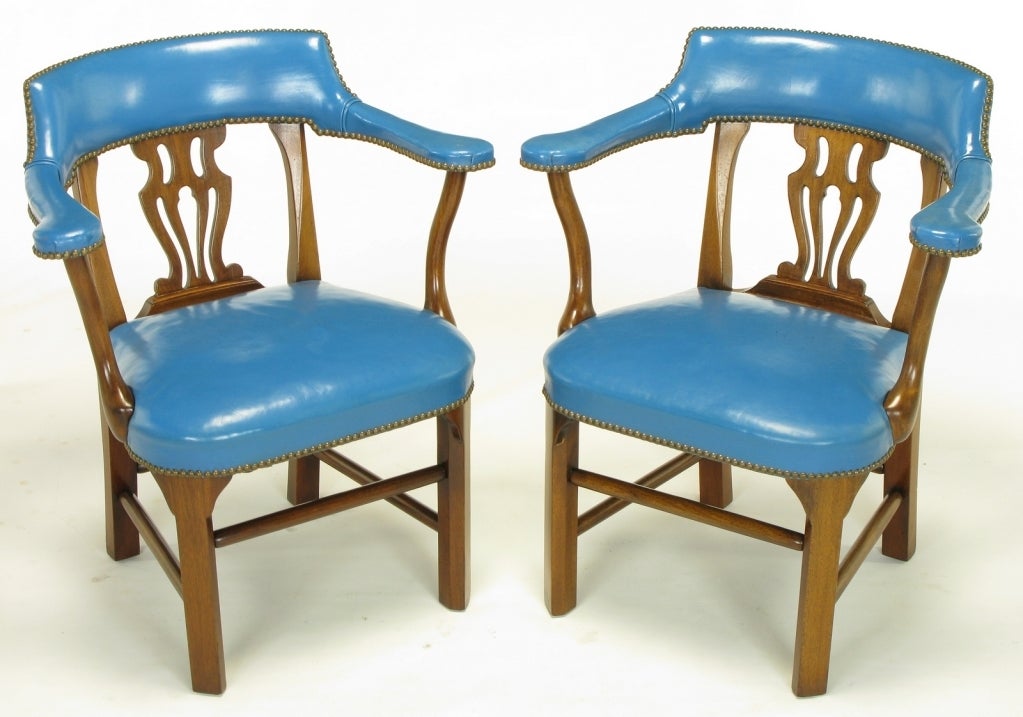 Pair of Chippendale influenced arm chairs from Barnard & Simonds, Rochester, NY. Cadet blue leather wrapped arms, back as well as seat with brass nail head details. Mahogany frames have canted front legs, Chippendale style open back and four part