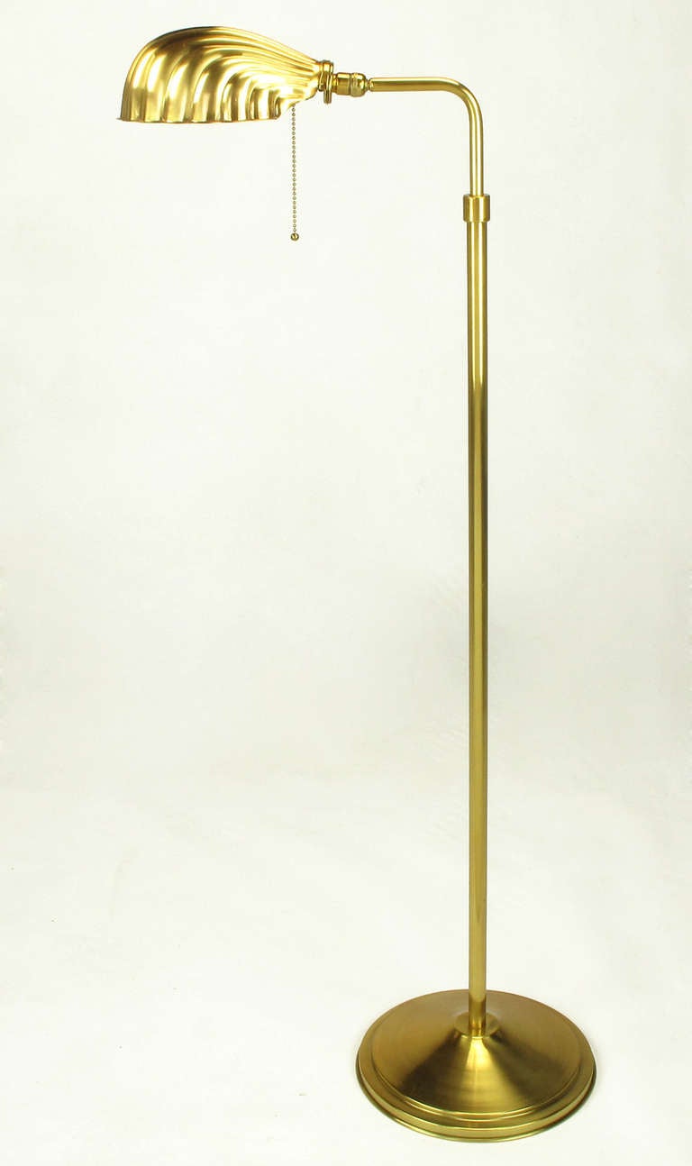 Brass floor/reading lamp with formed brass shell form shade. Incandescent lighting element, and 100 possible watts of illumination.

60