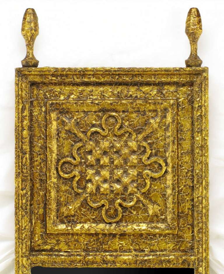 Engaging gilt textured finish on this tall Moorish style mirror with four point arrow recessed trumeau panel surmounted by a pair of finials.
