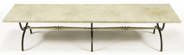 Beautifully refinished Tomlinson iron curule leg coffee table in a bleached walnut with driftwood grey glaze. The triple curule form hammered iron legs are lacquered satin black and spaced by carved wood stretchers with the same glazing as the top.