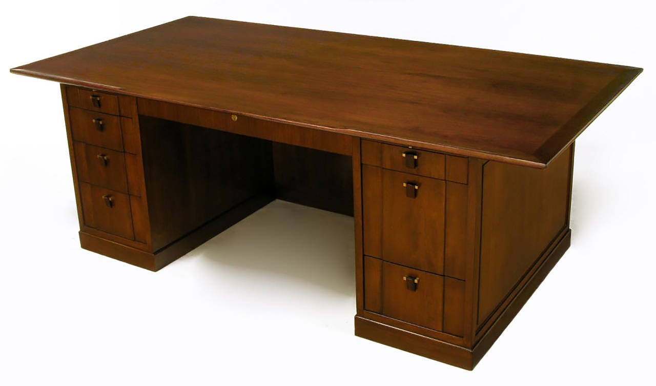 Rare Edward Wormley for Dunbar sculpted walnut and rosewood executive desk. Upturned carved lip to the solid walnut top that levels out at the knee hole center. Eight drawers with locking center drawer and hanging file drawer. Pull-out right and