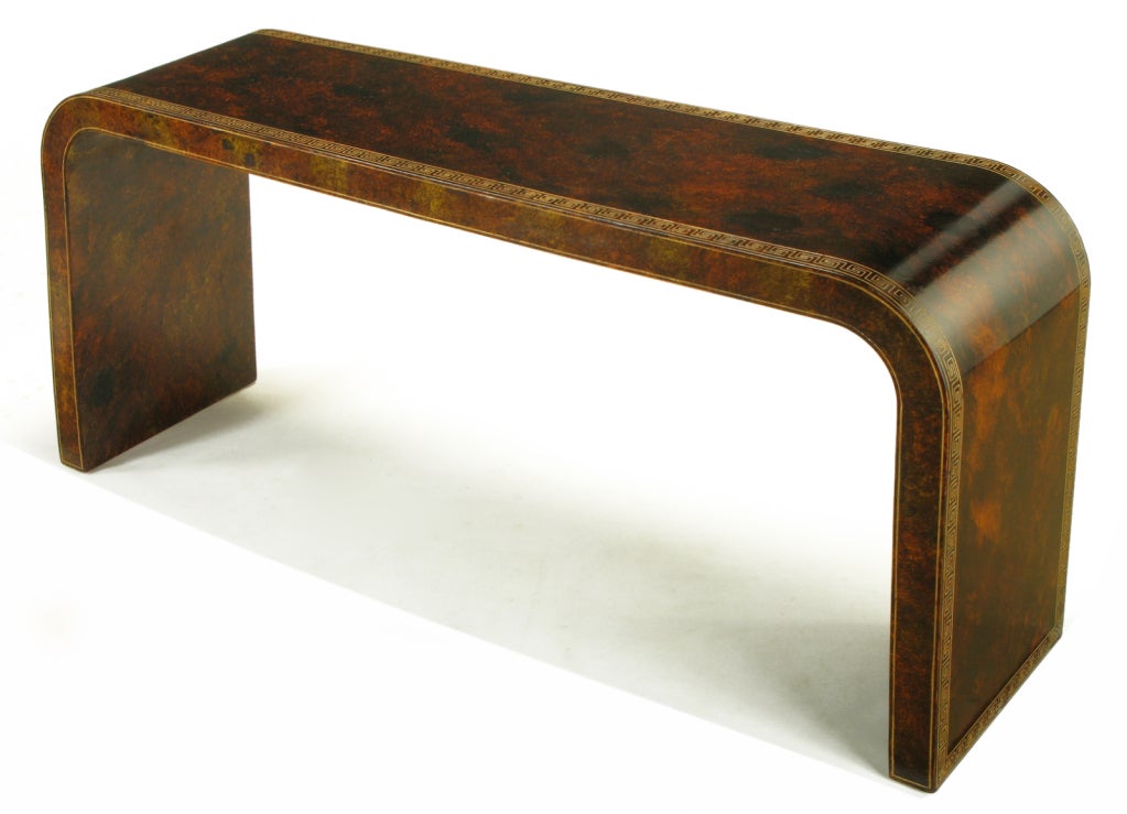 In a classic waterfall form, used often by Karl Springer, this custom console table is stunningly finished in a hand-stippled glazing over a Chinese red lacquer base to simulate tortoise shell.

Top and sides are decorated with an incised Greek
