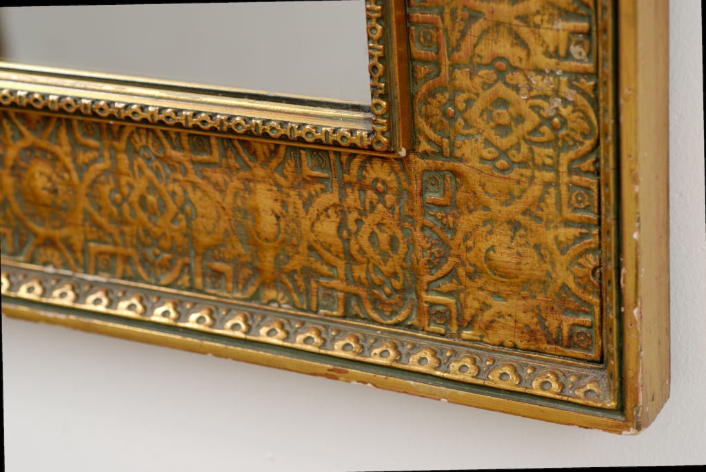 No doubt inspired by Howard Carter's 1922 discovery of King Tut's tomb, this large wall mirror has gesso and pressed tin decoration evocative of Egyptian ornament.
