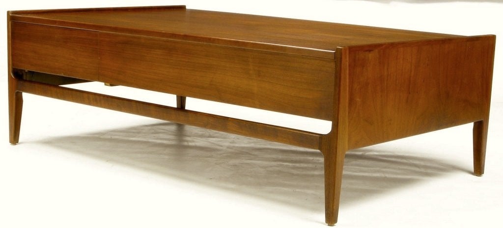 This clean lined coffee table by Richard Thompson reflects California modern at its best.  Constructed of walnut and oak, and finished in walnut veneer, the table features a concealed flush drawer for storage.