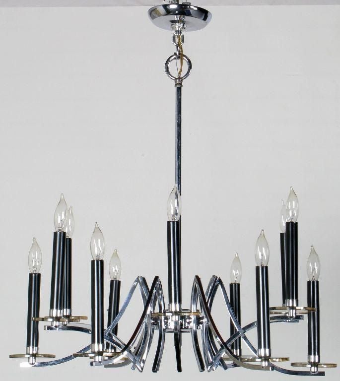Exquisite 12 arm ceiling fixture in chromed brass with an alternating over and under design. Each light features a black sheath and a smoked Lucite bobeche. Very striking modern chandelier.