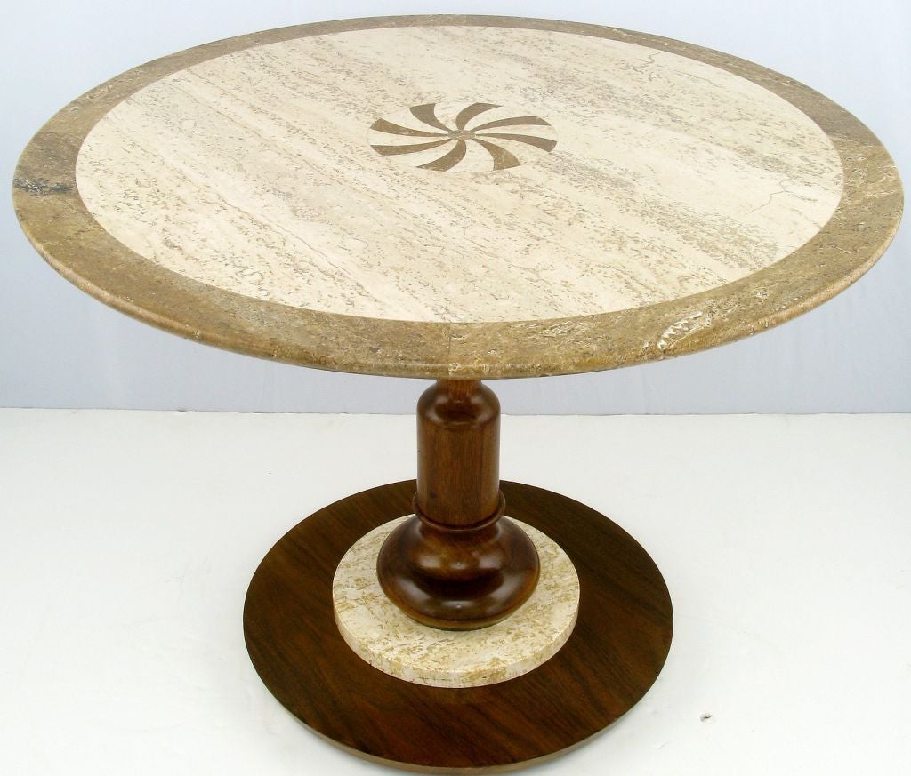 Stylish side table from Drexel with a polished cream and brown travertine top that features a pinwheel marquetry center. The base is a combination of layers in travertine and walnut with a sculptural walnut baluster pedestal.