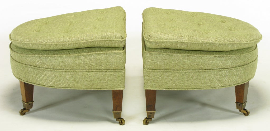 Very well executed pair of demilune ottomans or benches by Kittinger. They have a slight slope to the seating surface, allowing for comfortable and very elegant bench seating. Brass sabots with original brass casters, and celadon green linen