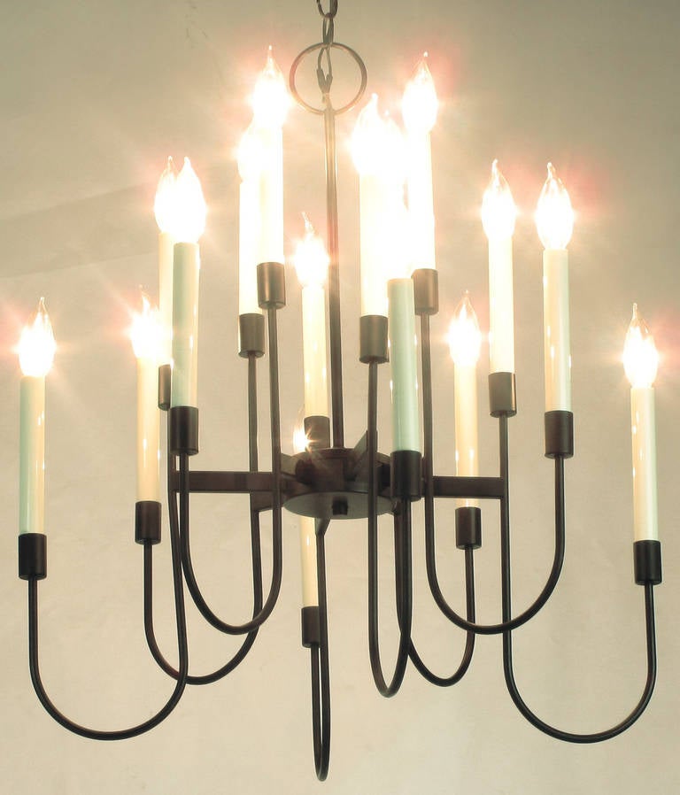 Elegant black lacquer sixteen-light chandelier by Lightolier. The design is often attributed to Tommi Parzinger. The chandelier is comprised of eight spokes radiating out from the centre disc, with each bar holding two lights on a curved rod. Comes