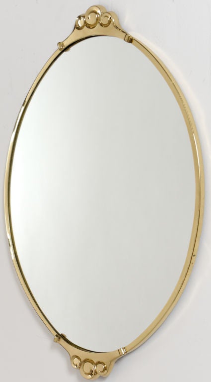 Delightfully sized oval mirror with brass framing. Has scroll ornament at both top and bottom. With application of felt to the back, could also be used as a perfume tray for a dressing table, or with a centerpiece in a dining table.