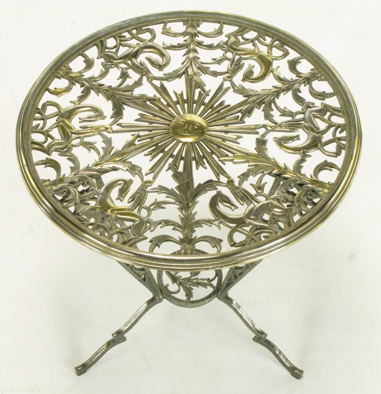 Intricately cast art deco tripodal side table by Rena Rosenthal. Table top is a beautifully detailed collage of foliage, African women on horses, and a beaming center sun with smiling face. Beveled top edge for a round glass insert. Three legs with