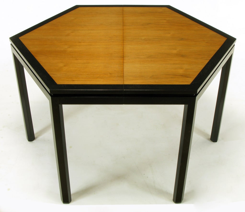 Uncommon hexagonal dining table by Edward Wormley for Dunbar. Tawi wood top, bordered with ebonized mahogany. Ebonized mahogany legs and notched apron. Sold with three offset grain Tawi wood 16