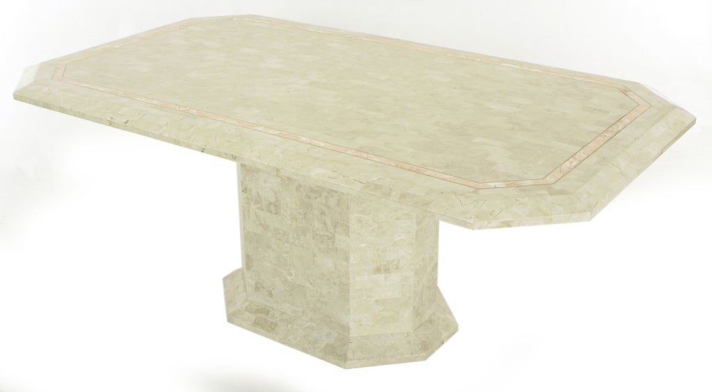 Tesselated fossil stone over wood pedestal table with rouge marble and brass inlaid border. Elongated octagon with form following pedestal base. Manufactured in the Philippines, where similar pieces by Karl Springer and Maitland Smith were made.