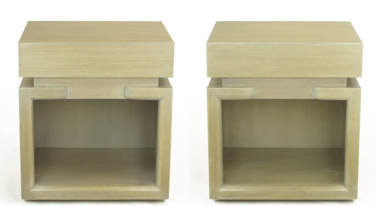 Two circa 1950 modern mahogany nightstands, refinished in driftwood color. Free of hardware to distract from the clean lines, single drawer top with solid mahogany surround open-cabinet base on recessed casters. Excellent build quality.