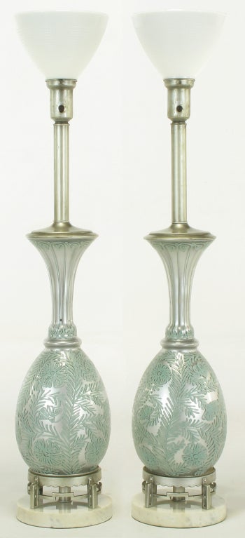 Pair of reverse silvered glass table lamps with hand-painted turquoise blue relief floral pattern. Silver lacquered cap, stem and cup with milk glass shades. Silver lacquered brass open pedestal on Carrara marble base.